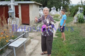 batrana cu un pisoi in brate in cimitir